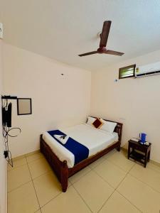 a bedroom with a bed and a ceiling fan at La town beach stay in Pondicherry