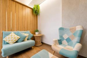 a living room with a blue couch and a chair at Mirador Torre de la Garrofa in Almería