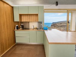 a kitchen with green cabinets and a large window at Mirador Torre de la Garrofa in Almería