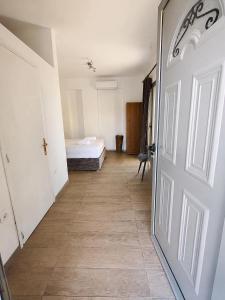 a hallway with a room with a bed and a door at Prestige Rooms Andros in Gavrio