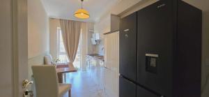 a kitchen with a black cabinet and a table at Apartament Green Tara in Oradea +19 photos