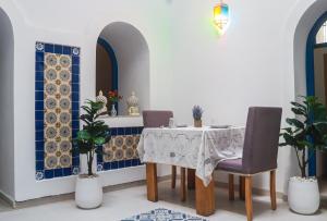 a dining room with a table and chairs and blue tiles at Dar Beate Sousse Medina in Sousse