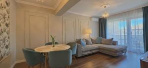 a living room with a couch and a table and chairs at Apartament Green Tara in Oradea