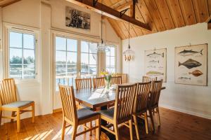 a dining room with a wooden table and chairs at Batalden Ishus in Kinn