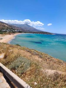 a view of a beach next to a body of water at Prestige Rooms Andros in Gavrio