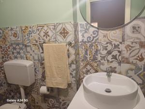 a bathroom with a sink and a toilet and a mirror at Domus San Francesco in Castelvetrano Selinunte