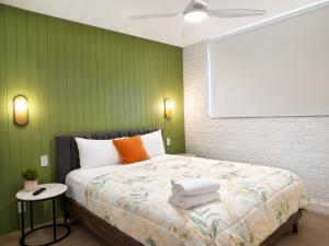 a bedroom with a bed with a green wall at Dunes Apartment Unit 8- GROUND FLOOR WITH POOL VIEW in Coffs Harbour