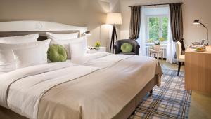 a bedroom with a large white bed and a desk at Hotel Jagdschloss Kranichstein in Darmstadt +38 photos