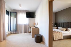 a bedroom with a bed and a desk and a television at Royal Airport Hotel in Velika Gorica +108 photos