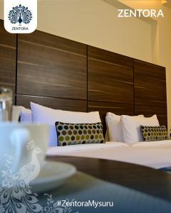 a bedroom with two beds and a wooden headboard at Zentora in Belagula