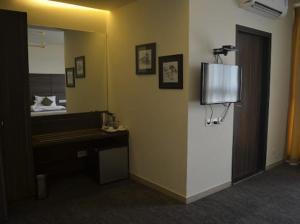 a room with a mirror and a desk and a bed at Zentora in Belagula