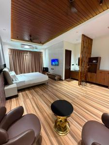 a hotel room with a bed and a living room at Sri Vasavi Regency in Mahabalipuram