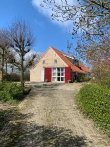 a brick road leading to a red barn at B & B it Heech in Ferwerd