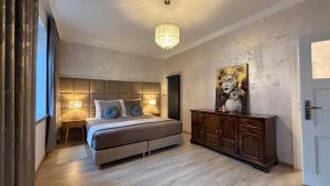 a bedroom with a bed and a desk and a chandelier at "Na Prostej" Old Town Apartment in Olsztyn +8 photos
