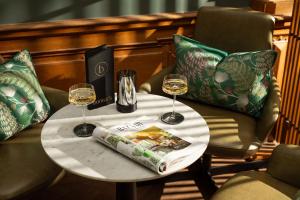 a table with two glasses of wine and a book at The Scott in Edinburgh