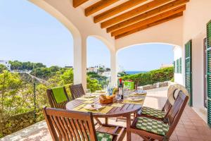 a patio with a table and chairs on a balcony at Villa Olga in Cala en Porter