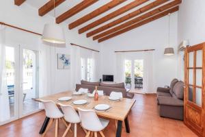 a living room with a wooden table and chairs at Villa Olga in Cala en Porter