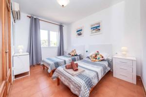 a bedroom with two beds and a window at Villa Olga in Cala en Porter +12 photos
