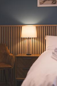a bedroom with a bed and a lamp and a chair at The Ford Apartment in Perth
