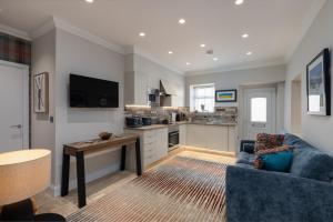 a living room with a blue couch and a kitchen at The Ford Apartment in Perth