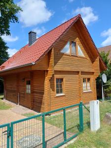a wooden house with a red roof at Holiday Home Fleesensee in Göhren-Lebbin
