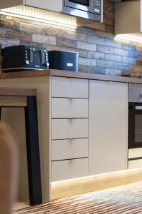 a kitchen with white cabinets and a microwave at The Ford Apartment in Perth +3 photos