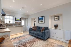 a living room with a couch and a kitchen at The Ford Apartment in Perth