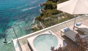 a view of the ocean from a house with an umbrella at The Donna Portals in Portals Nous