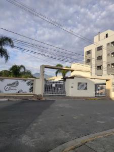 a building with a gate in front of a street at Apt confortável in Camboriú