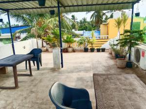 a patio with chairs and a table and potted plants at La town beach stay in Pondicherry