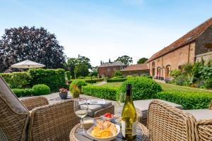 a table with a bottle of wine and a plate of food at 1 Bed in Driffield oc-79277 in Wold Newton