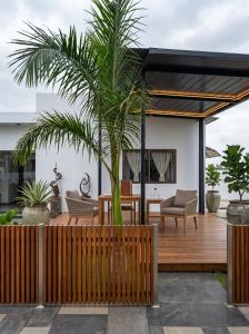 a house with a palm tree on a wooden deck at White house Residences by Pebbles in Lusaka