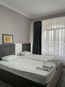 a bedroom with a large bed with a window at Osh Art Hotel in Osh