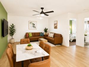 a living room with a table and a couch at Dunes Apartment Unit 8- GROUND FLOOR WITH POOL VIEW in Coffs Harbour +6 photos