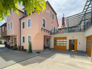 a large pink house with a garage at Ferienwohnung Binder - Ferienwohnung Bad Windsheim in Bad Windsheim