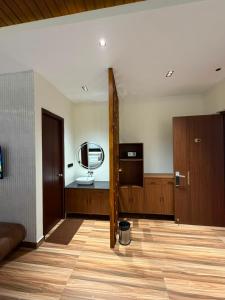 a living room with a couch and a mirror at Sri Vasavi Regency in Mahabalipuram