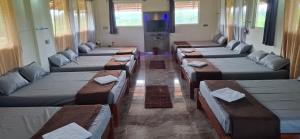 a room with many beds and tables and a tv at New Peak By The Lake in Chikmagalūr
