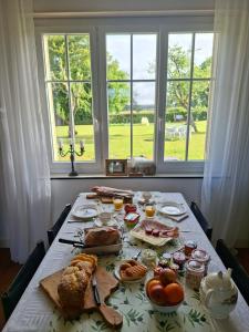 a table with food and drinks on it with windows at C'est Si Bon in Vandenesse