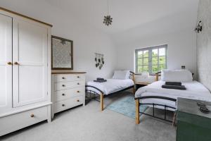 a white bedroom with two beds and a dresser at 7 Bed in Coltishall oc-m31936 in Coltishall