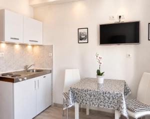 a kitchen and dining room with a table and a sink at Villa Bingo in Cavtat