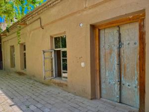 an old building with two doors on the side of it at Aziz Guest House in Samarkand +8 photos