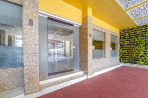 a room with a red carpet and a wall with mirrors at Townhouse Oak Kozhikode Bus Stand Formerly Nextel Inn in Kozhikode +32 photos