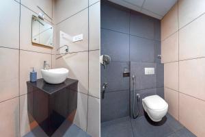 a bathroom with a toilet and a sink and a shower at Townhouse Oak Kozhikode Bus Stand Formerly Nextel Inn in Kozhikode
