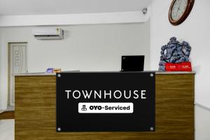 a sign for a town house on a desk at Super Townhouse Financial District Gachibowli Formerly Srinika Inn in Hyderabad