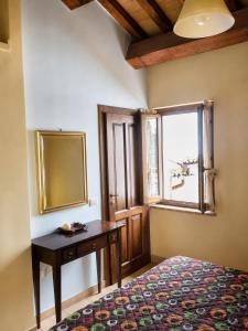 a bedroom with a table and a mirror and a window at Turris Morro di Rasiglia in Rasiglia
