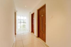 a hallway with a wooden door and a tile floor at Collection O Kottayam Railway Station in Kottayam