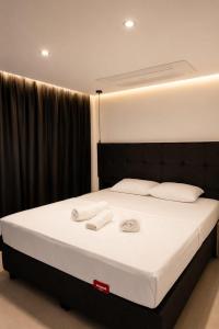 a bedroom with a bed with two towels on it at Bodrum Has Apart Otel in Bodrum City