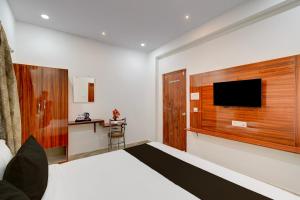 a hotel room with a bed and a flat screen tv at Super Townhouse Telapur Junction Formerly Fortune Inn in Hyderabad