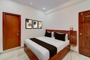 a bedroom with a bed and a wooden door at Super Townhouse Telapur Junction Formerly Fortune Inn in Hyderabad