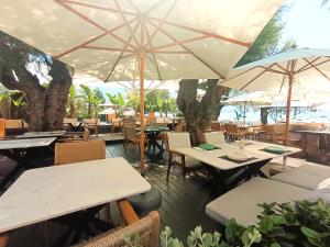 a restaurant with tables and chairs and umbrellas at TAYS Hotel in Kalamata